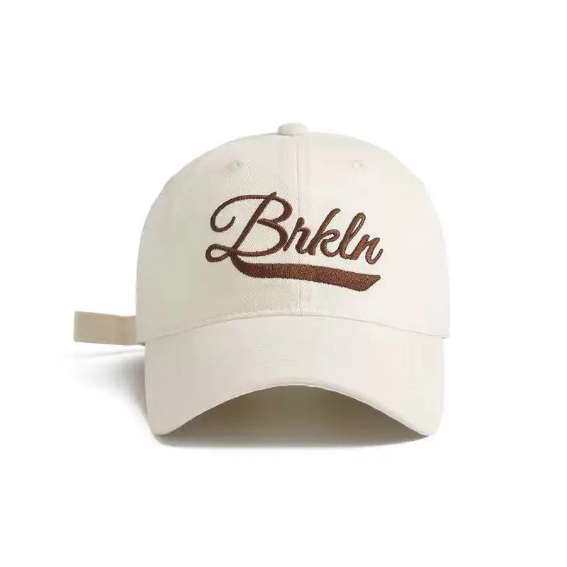 An image of a  Creme Brooklyn Script Embroidery Cap by  Mirra Masa