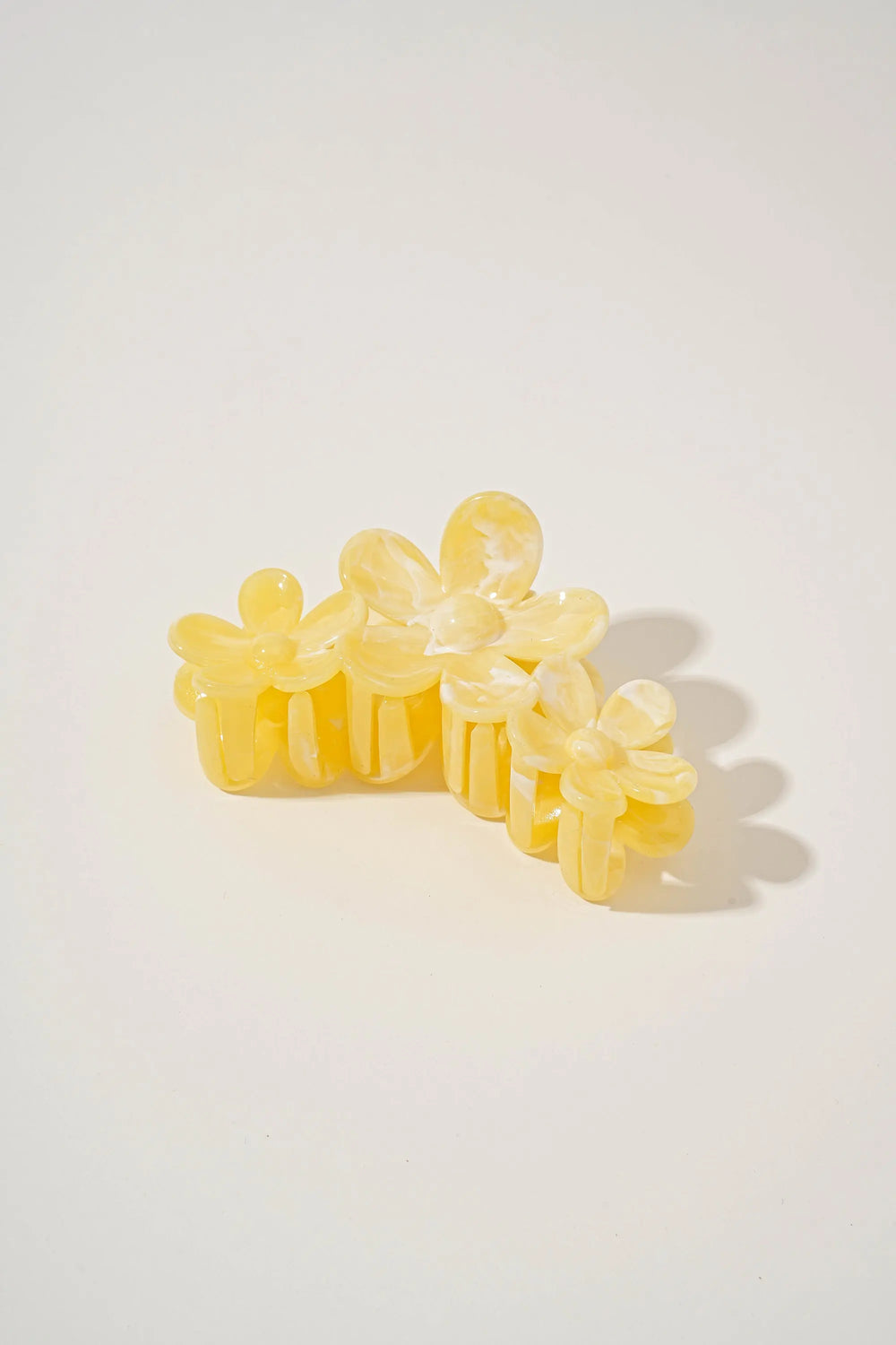 An image of a   Glossy Marbled Trio-Flower Hair Claw by  Mirra Masa