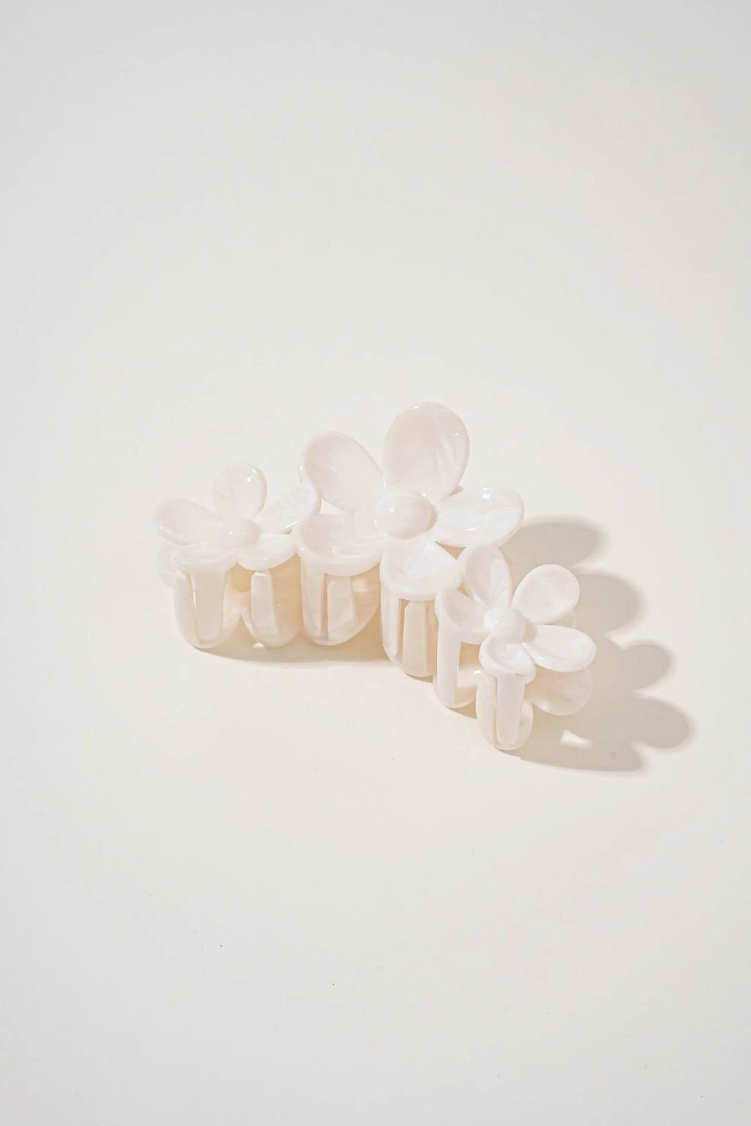 An image of a   Glossy Marbled Trio-Flower Hair Claw by  Mirra Masa