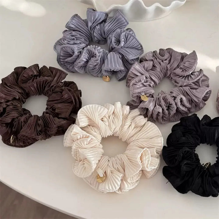 An image of a   Pleated Charm Scrunchie by  Mirra Masa