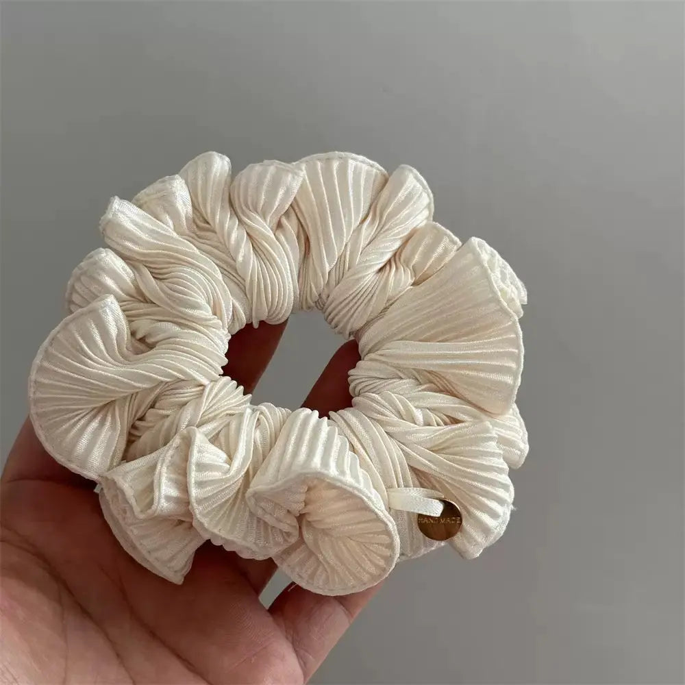 An image of a   Pleated Charm Scrunchie by  Mirra Masa