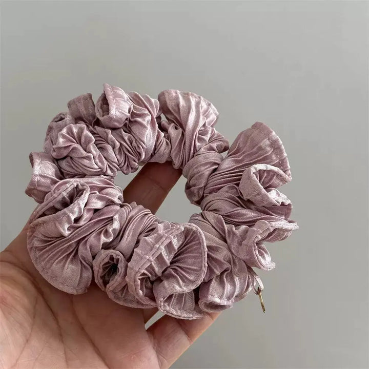 An image of a   Pleated Charm Scrunchie by  Mirra Masa
