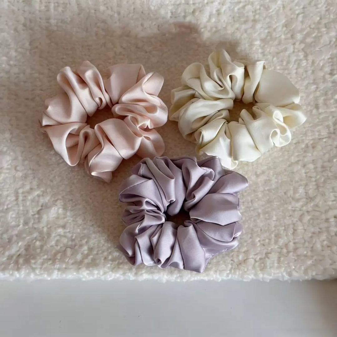 An image of a   Satin Ruched Scrunchie by  Mirra Masa