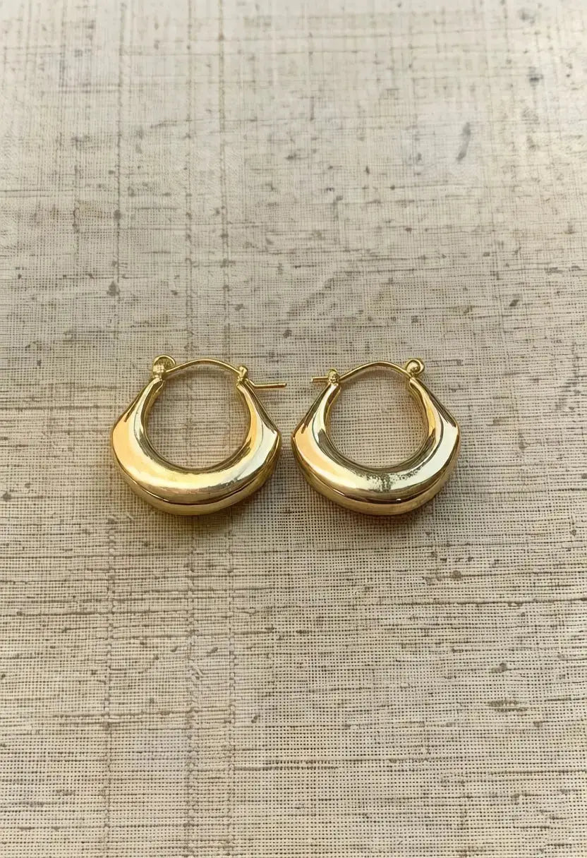 An image of a   Tapered Crescent Hoop Earrings by  Mirra Masa