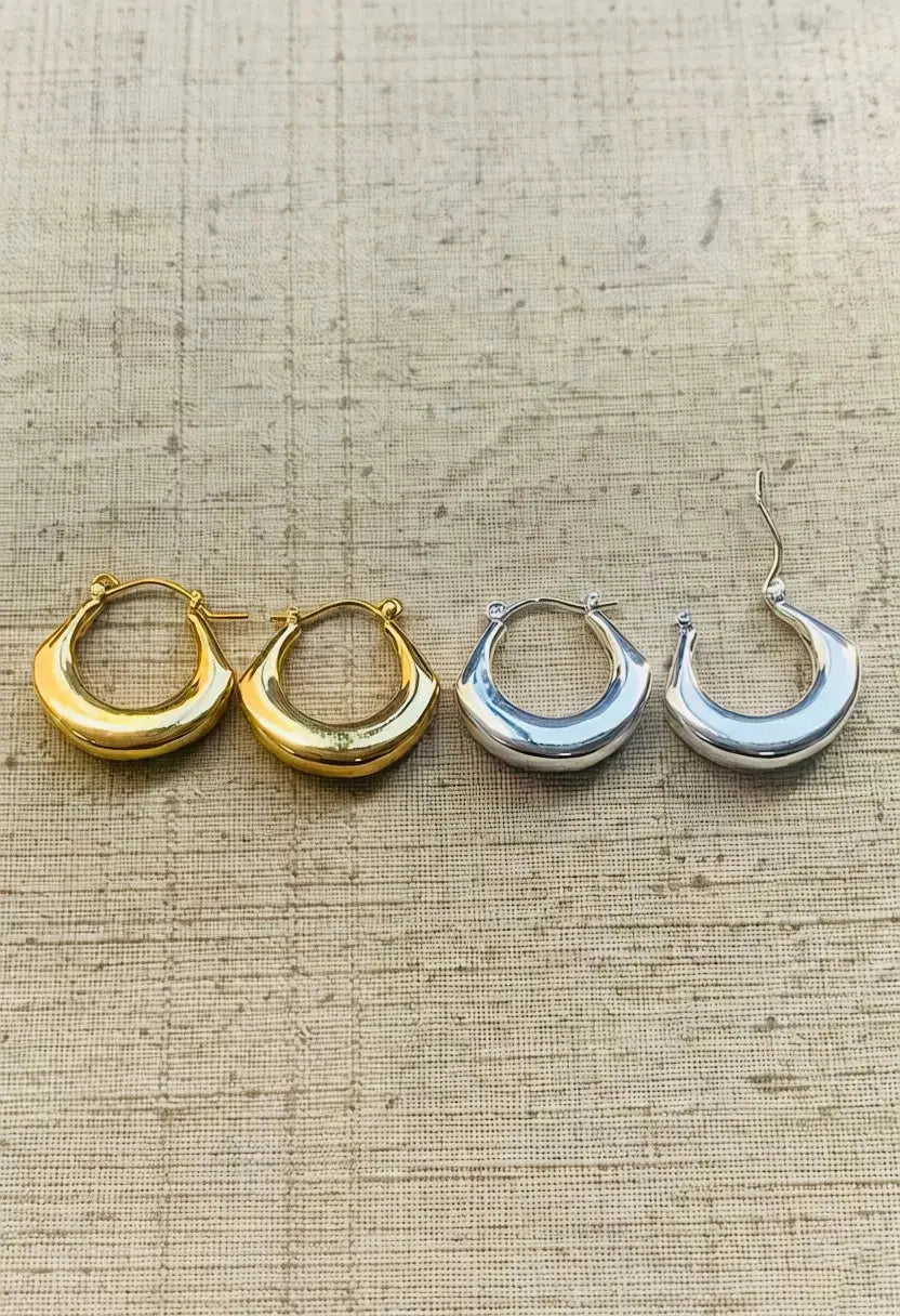 An image of a   Tapered Crescent Hoop Earrings by  Mirra Masa