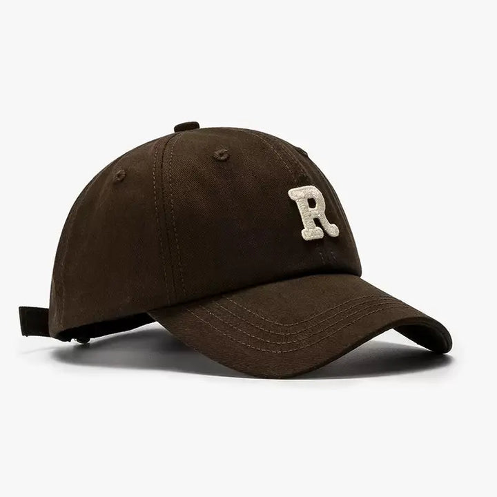 An image of a  Dark Brown Terry R Letter Baseball Cap by  Mirra Masa